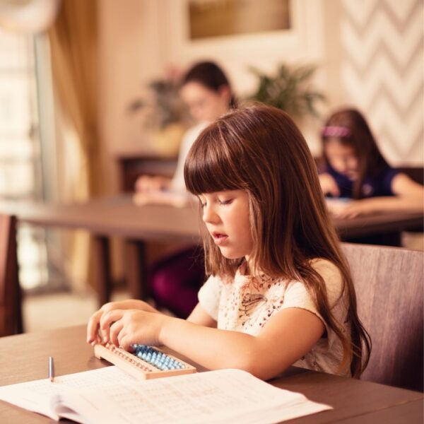 Une petite fille apprend les bases des mathématiques et du calcul mental avec le boulier.