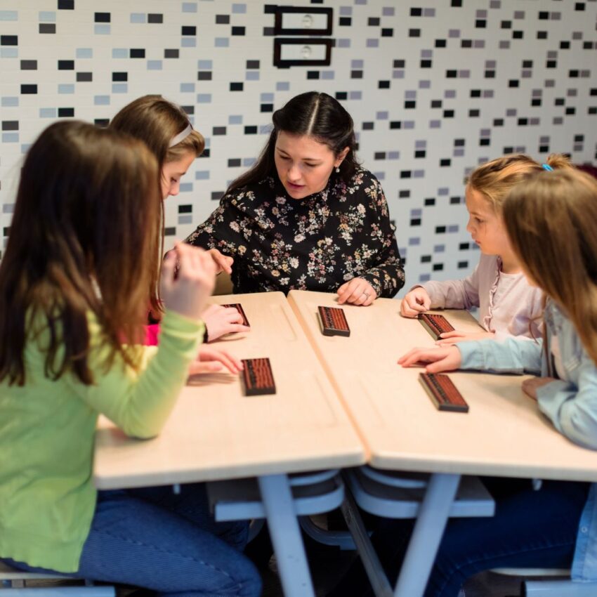 Un groupe d'enfants apprend les bases des maths et du calcul mental grâce au boulier.